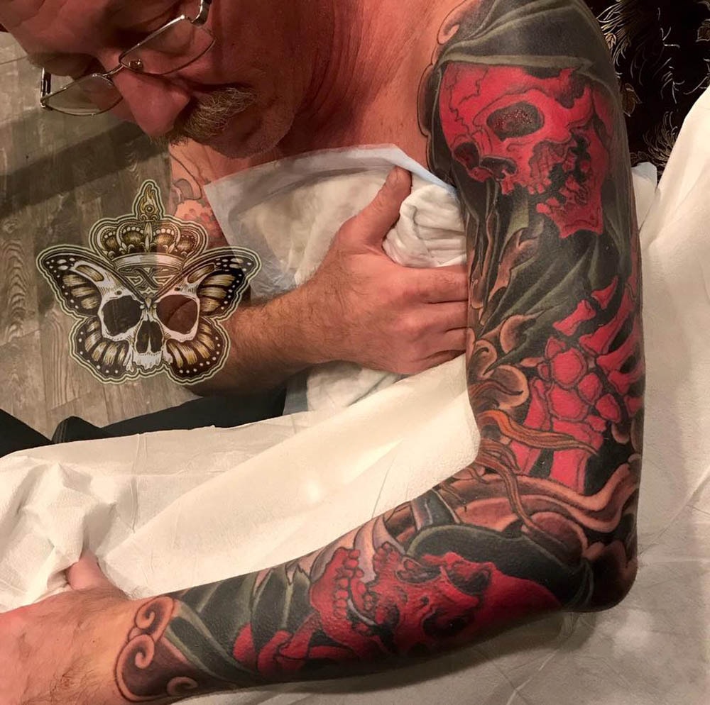 Red skull sleeve tattoo in progress